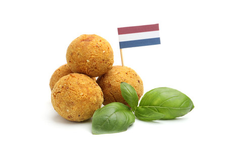 Delicious fried croquette balls, basil and small flag of Netherlands isolated on whiteの写真素材