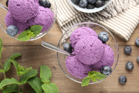Tasty sorbet with blueberries and mint in dessert bowls on wooden table, flat layの写真素材