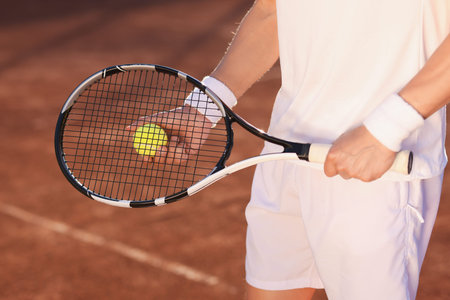 Man with tennis racket and ball at court, closeupの写真素材