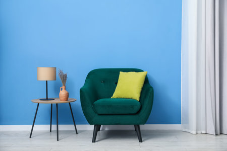 Comfortable armchair and decor near blue wall indoorsの写真素材