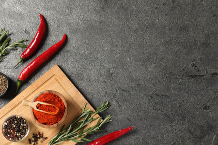 Different aromatic spices on gray table, flat lay. Space for text