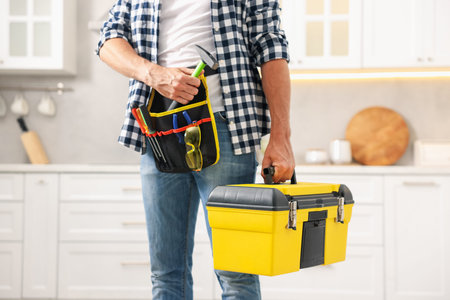 Professional repairman with tool box indoors, closeup