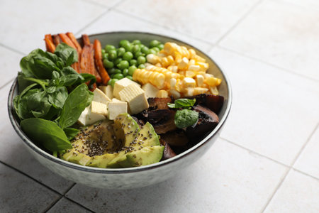 Healthy vegetarian food. Delicious Buddha bowl on light tiled table, closeup. Space for textの写真素材