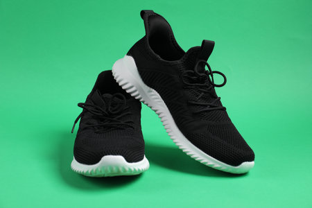 Pair of black sneakers on green backgroundの写真素材