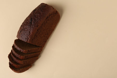 Fresh rye bread on beige background, above view. Space for text