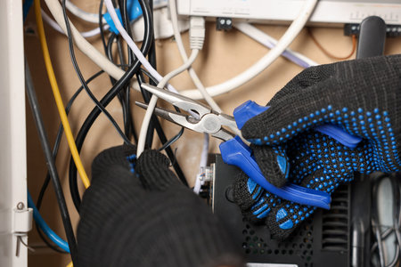 Man fixing heating radiator with pliers indoors, closeup