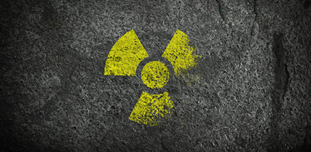 Yellow radioactive sign on dark stone background, banner design. Radiological pollution