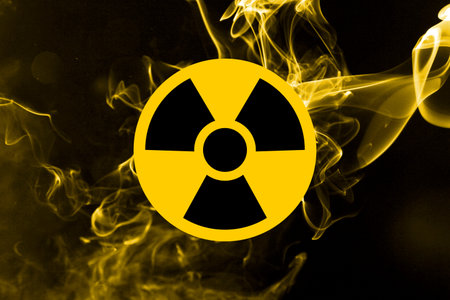 Radioactive sign and yellow toxic smoke against black background