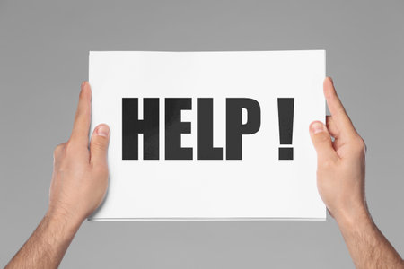 Man holding paper with word against grey background, closeupの写真素材