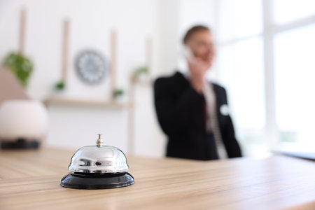 Receptionist working in hotel, focus on service bell