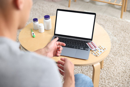 Man having online consultation with doctor via laptop at home, above viewの写真素材