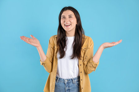 Portrait of surprised woman on light blue background
