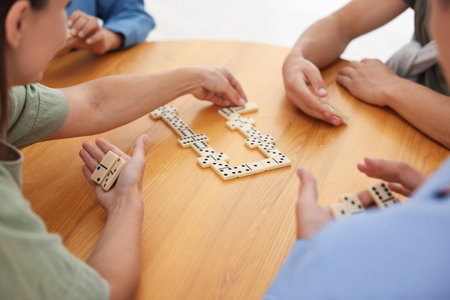 Friends playing dominoes at wooden table, closeupの写真素材