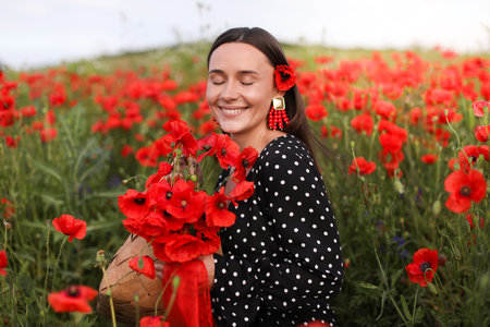 Smiling woman with bag among red poppy flowers in wildflower meadowの写真素材