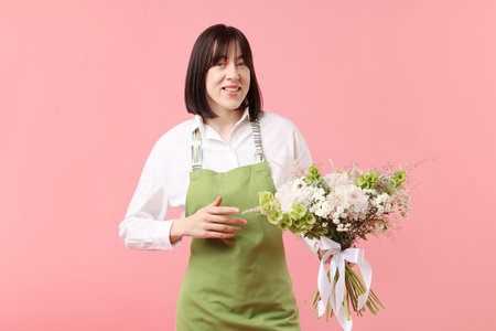 Florist with beautiful bouquet of flowers on pink backgroundの写真素材