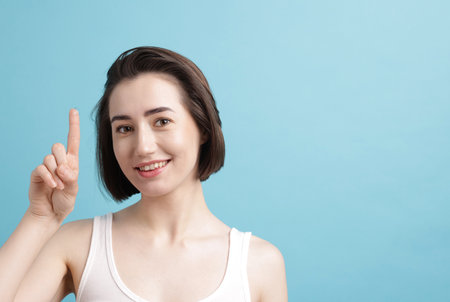 Woman with contact lens on light blue background. Space for textの写真素材