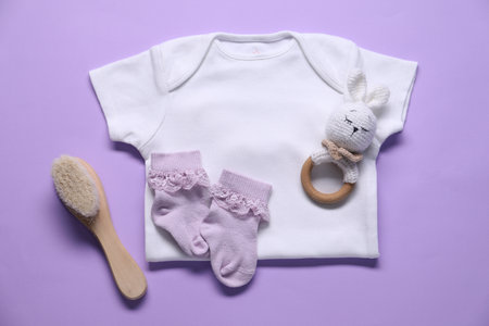Baby clothes and accessories on violet background, flat layの写真素材