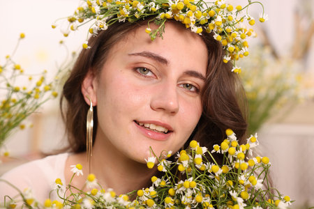 Portrait of beautiful woman with chamomile flowers indoorsの写真素材