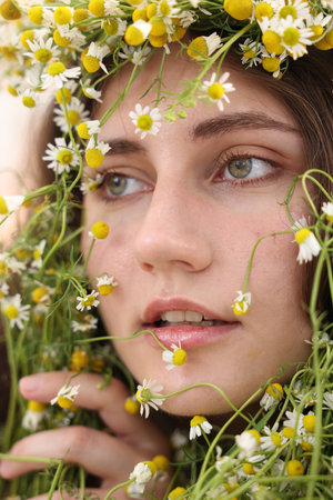 Portrait of beautiful woman with chamomile flowers, closeupの写真素材
