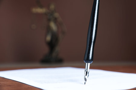 Signing notary document with fountain pen at table against brown background, closeup