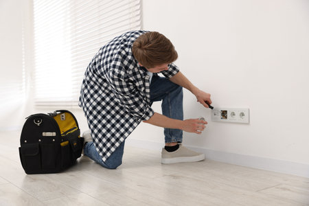Man with tools installing new socket at home