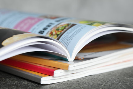 Stack of different magazines on grey table, closeupの写真素材