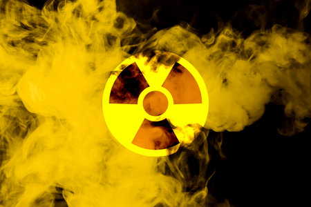 Radioactive sign and yellow toxic smoke against black backgroundの写真素材