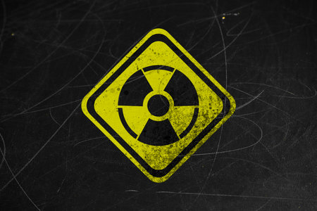 Yellow radioactive sign on scratched black surface. Radiological pollutionの写真素材