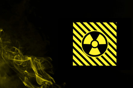 Radioactive sign and yellow toxic smoke against black background