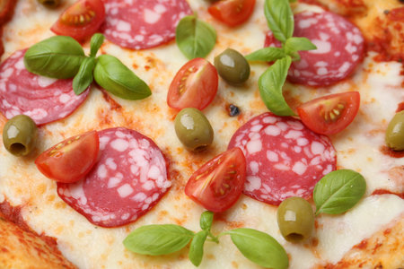 Delicious pizza with salami, olives, tomatoes and basil as background, closeupの写真素材