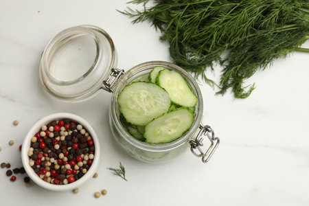 Making pickles. Fresh cucumbers and other ingredients on white table, flat layの写真素材