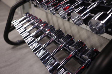 Many metal dumbbells on stand in gym, closeupの写真素材