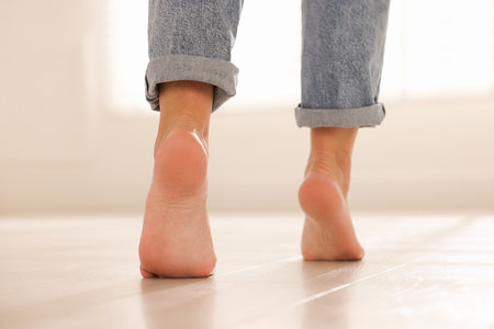 Woman walking on warm floor indoors, closeup. Heating systemの写真素材