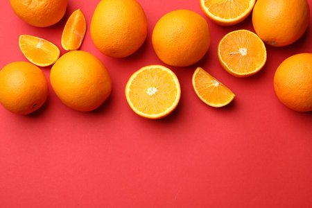 Fresh ripe oranges on red background, flat lay. Space for textの写真素材
