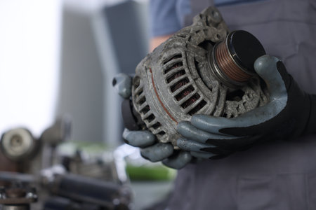 Auto parts. Professional mechanic with alternator near indoors, closeup. Space for textの写真素材