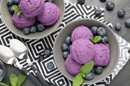 Tasty sorbet with blueberries and mint on black table, flat layの写真素材