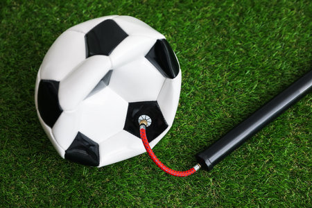 Soccer ball and manual air pump on artificial grassの写真素材