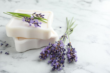 Soap bars and lavender flowers on white marble table, closeup. Space for textの写真素材