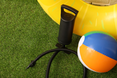 Ball, inflatable ring and manual air pump on artificial grass. Space for textの写真素材