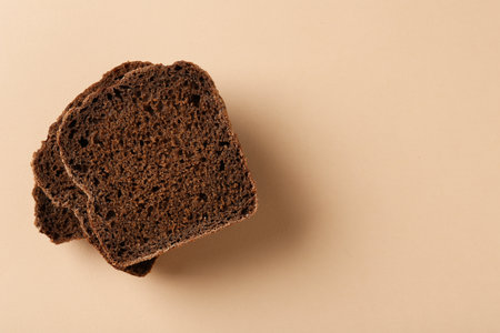 Pieces of fresh rye bread on beige background, top view. Space for textの写真素材