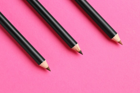Different eyebrow pencils on bright pink background, flat lay. Space for textの写真素材
