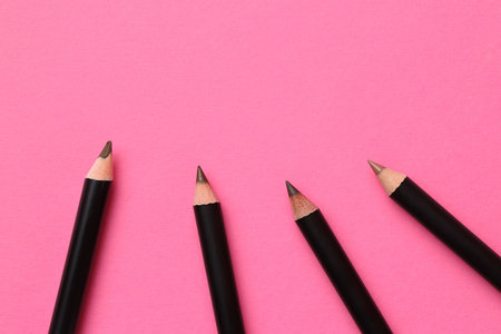 Different eyebrow pencils on bright pink background, flat lay. Space for textの写真素材