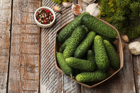 Making pickles. Fresh cucumbers and spices on wooden table, flat lay. Space for textの写真素材