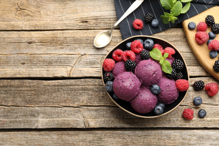 Delicious sorbet, fresh berries and mint on wooden table, flat lay. Space for textの写真素材