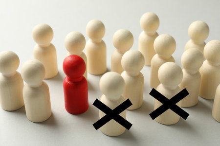 Dismissal. Two human figures with black crosses among others on white tableの写真素材