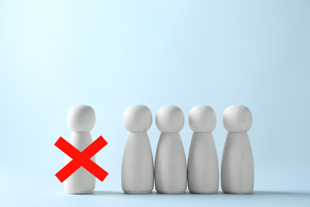 Dismissal. One human figure with red cross among others against light blue backgroundの写真素材