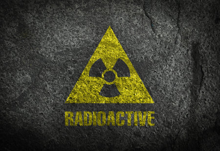Radioactive sign on dark gray textured surface. Radiological pollution