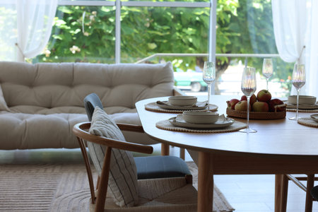 Beautiful table setting, chairs and decor in dining room. Interior design