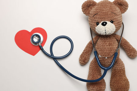 Pediatrics concept. Toy bear with stethoscope on white background, top viewの写真素材
