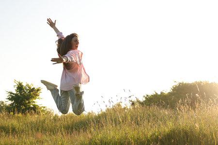 Feeling freedom. Happy young woman jumping in nature, space for textの写真素材